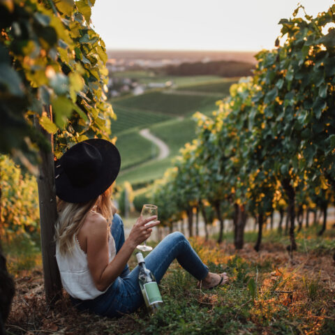 young-blonde-woman-relaxing-vineyards-summer-season-with-bottle-wine